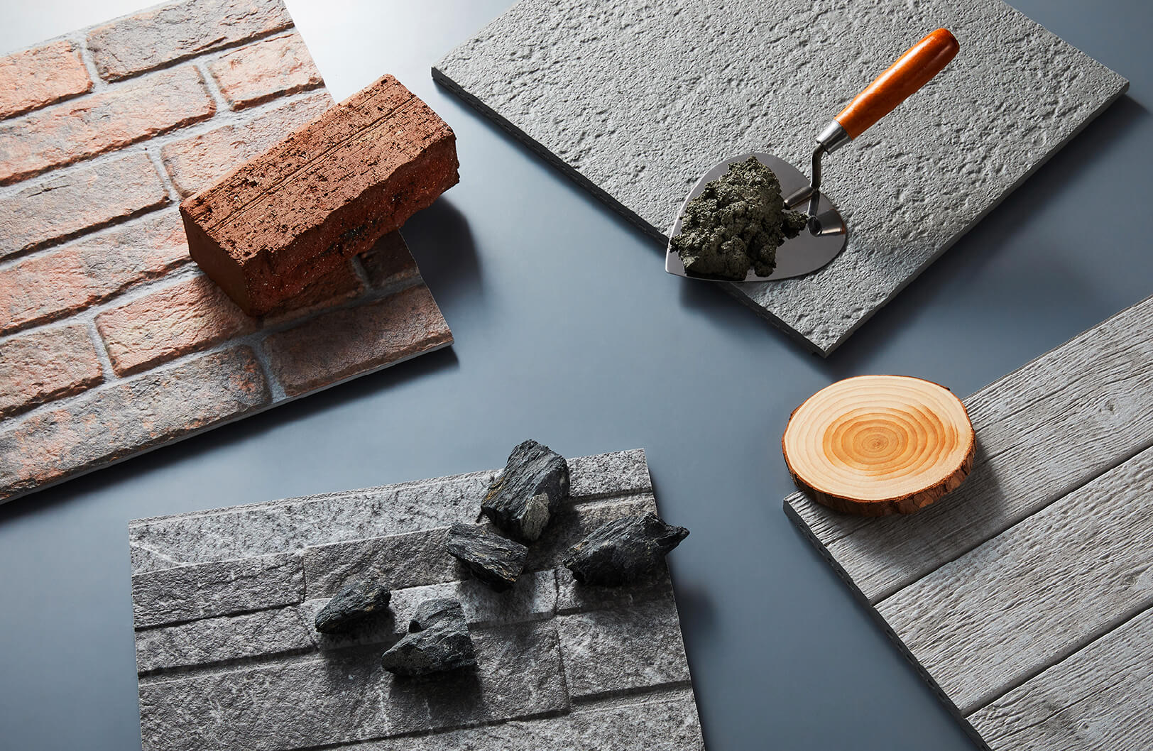 KMEW facade panels photographed alongside real brick, stone, and concrete, showcasing realistic reproduction of natural textures and design.