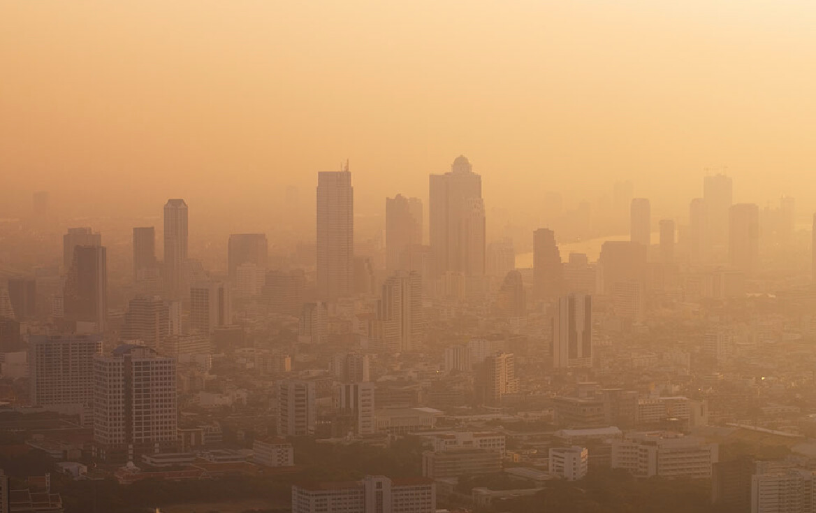 A city skyline covered in yellow dust, with tall buildings barely visible through the dust storm