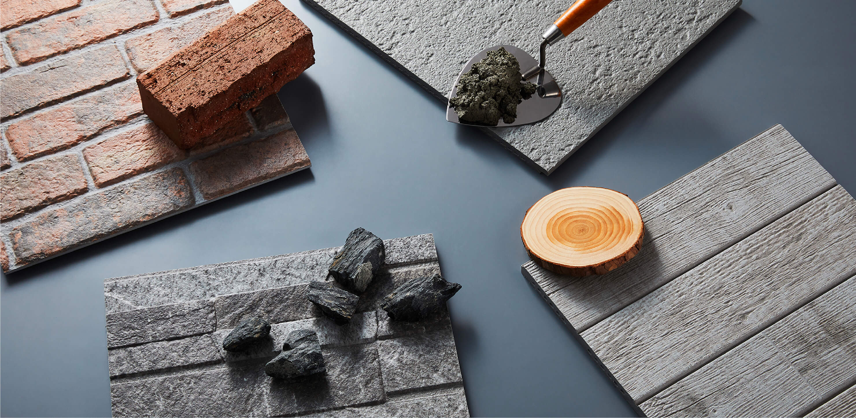 KMEW facade panels photographed alongside real brick, stone, and concrete, showcasing realistic reproduction of natural textures and design